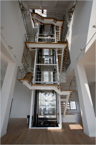 The glass elevator and exposed staircase in DUMBO's Clocktower Penthouse Apartment.